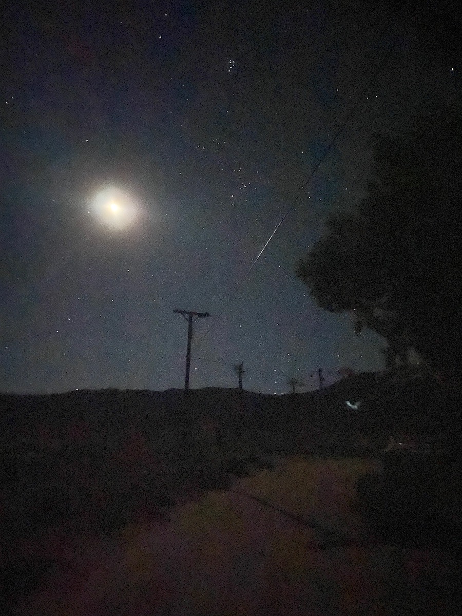 A bright moon, Hyades, and the Pleiades rising in the east over telephone poles and telephone wires